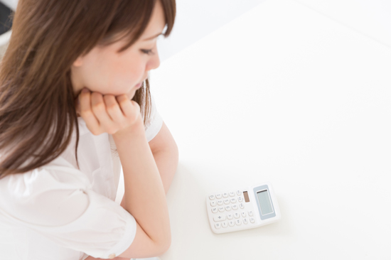 電卓を見つめる主婦