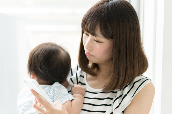 スマホチェックをする妻