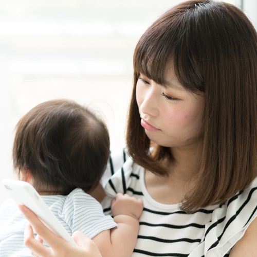 スマホチェックをする妻