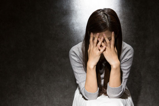 顔を手で覆う女性