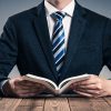 本を開くスーツ姿の男性i