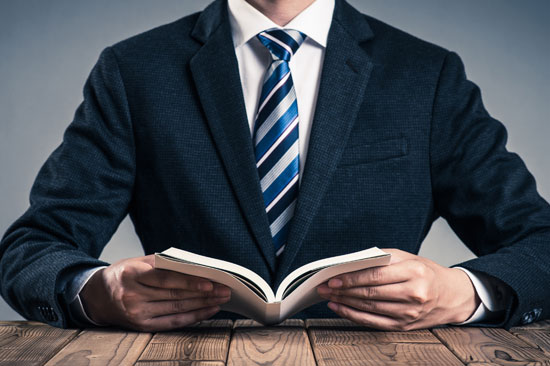本を開くスーツ姿の男性