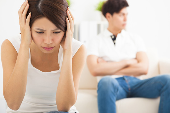 両手を頭に当てる女性