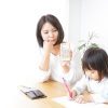 電卓を持つ母親と子ども
